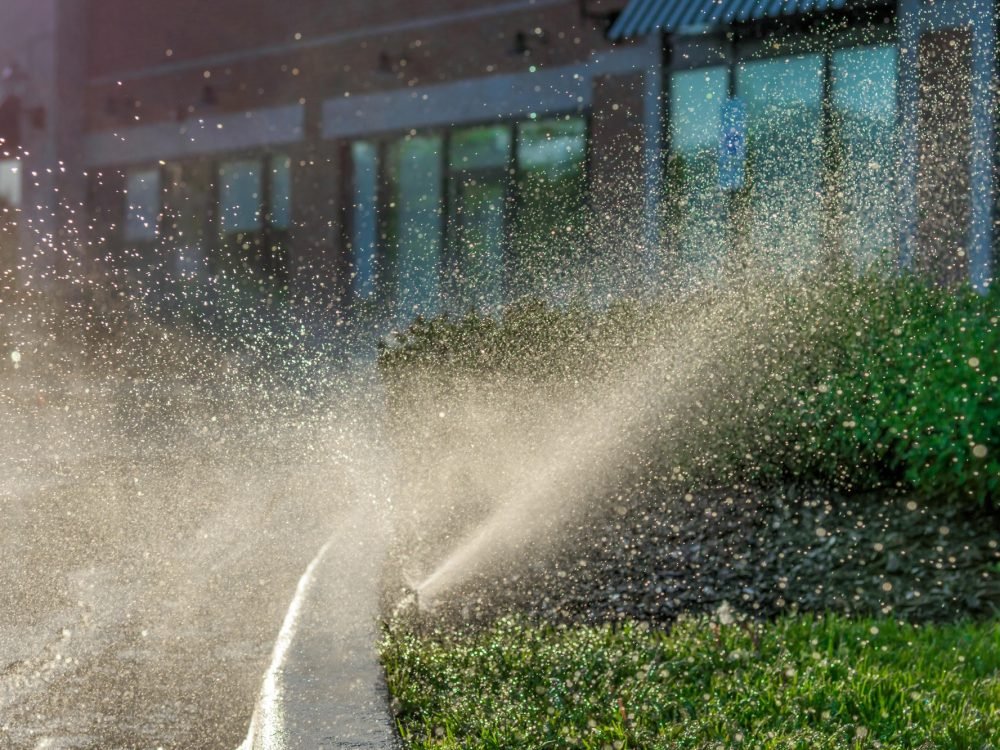 automatic sprinkler system spraying in the sunlight